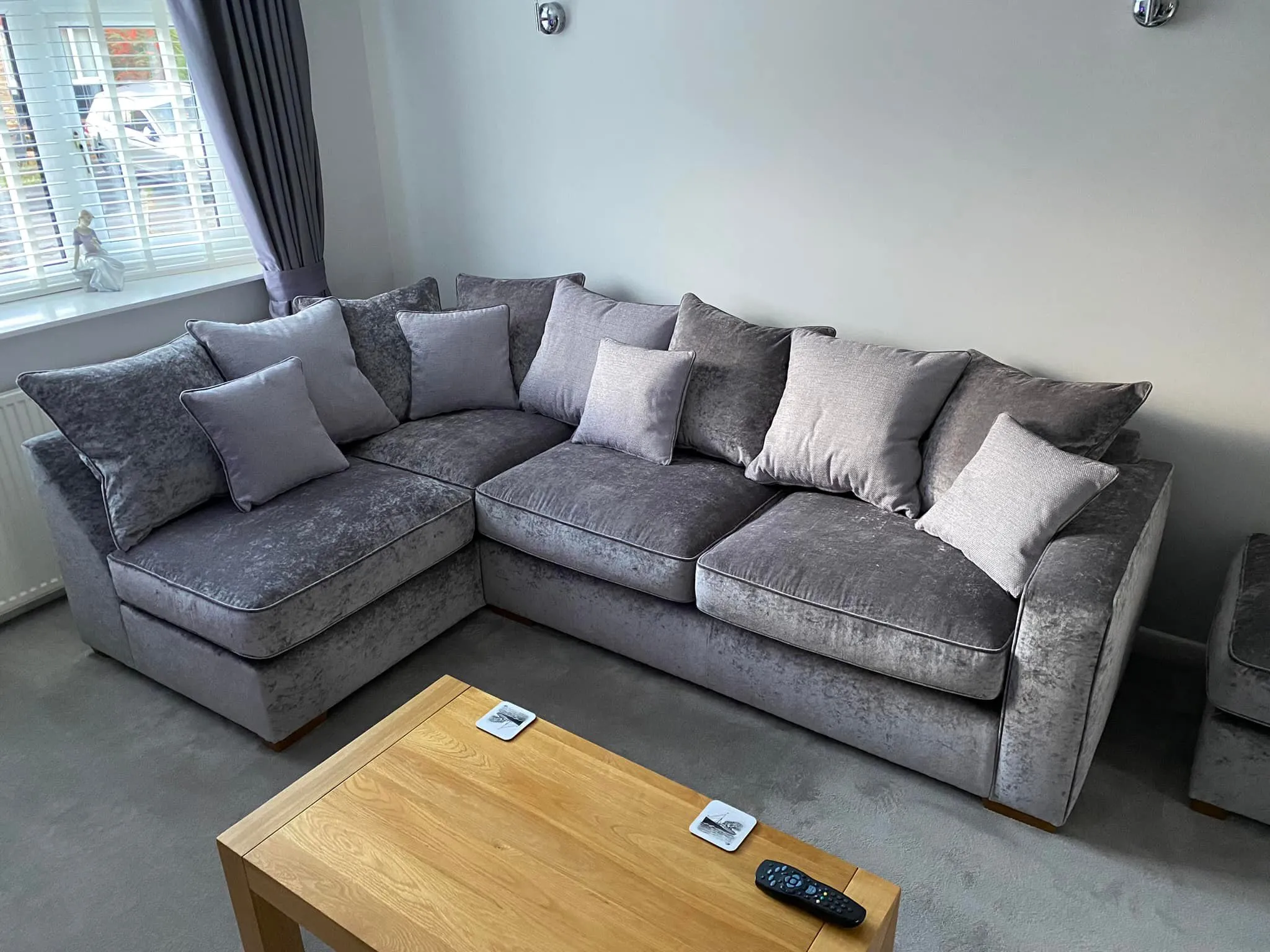 A modern grey sectional sofa with decorative pillows, paired with a sleek coffee table in a comfortable lounge area.