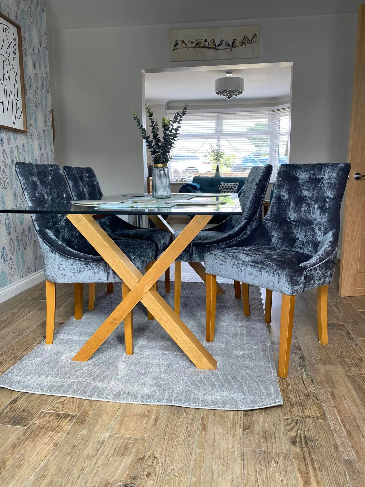 A sleek glass dining table accompanied by four contemporary chairs, perfect for a stylish dining area.